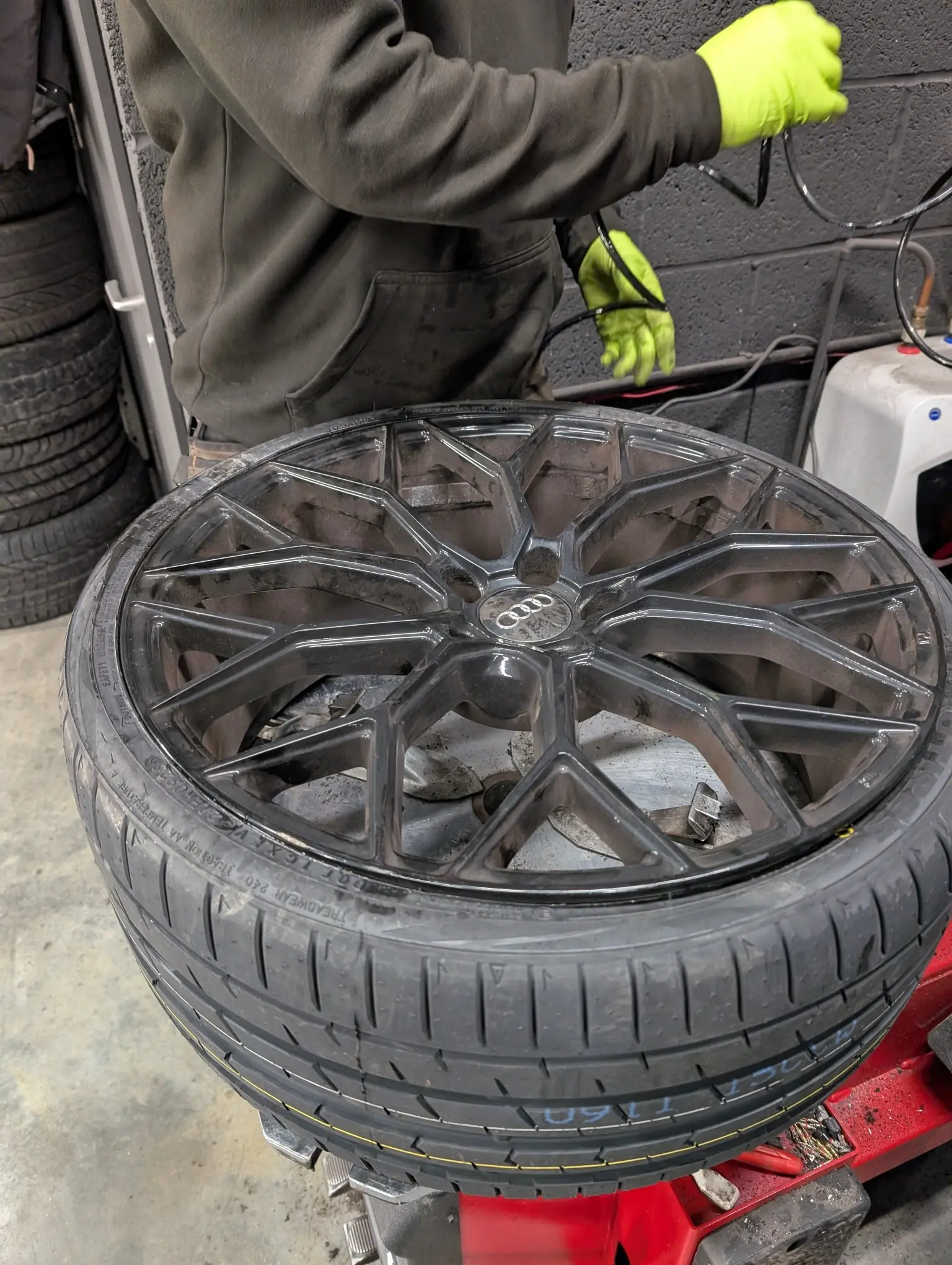 Technician fitting a tyre to an Audi alloy wheel in the workshop